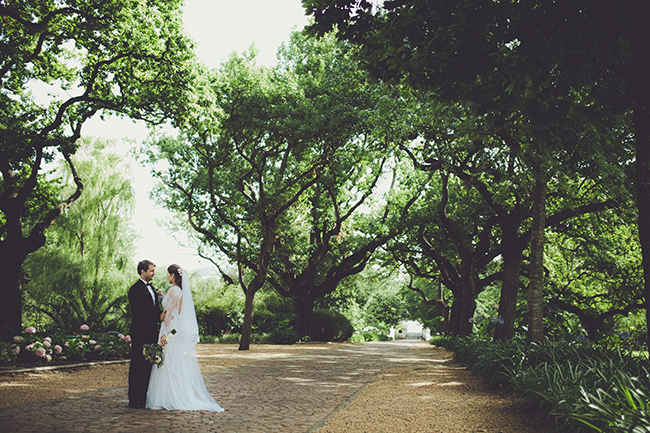 Wedding couple standing amongst the trees